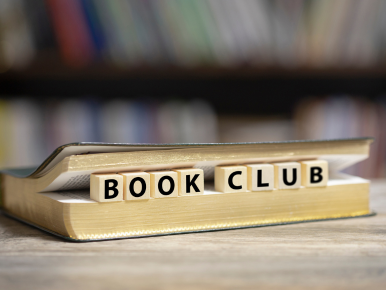 The words "Book Club" on titles laid out between pages of a book.