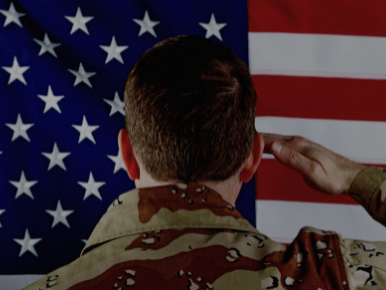 American flag with a soldier facing it and saluting