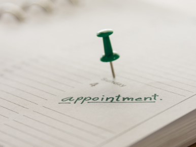 Picture of a green thumbtack holding a paper that says appointment