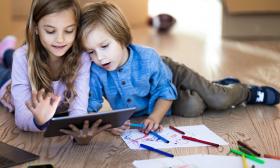 two kids looking at an ipad